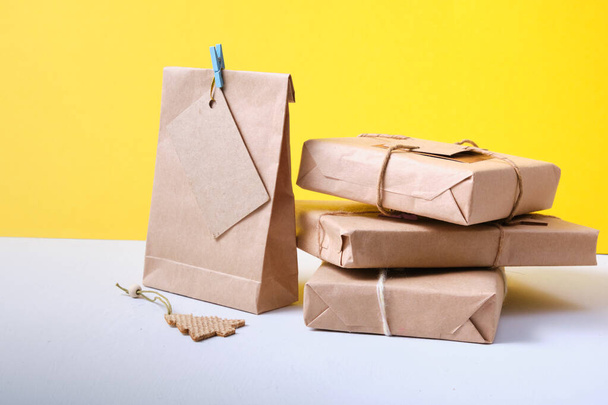 gifts packed in eco paper on a yellow background, zero waste lifestyle concept, packaging for DIY gifts - Photo, image