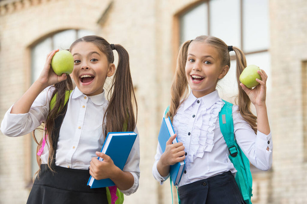 Students girls classmates with backpacks having school lunch, hungry kids concept - 写真・画像