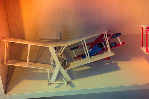 Kleines Retro-Spielzeugflugzeug im Regal - Foto, Bild