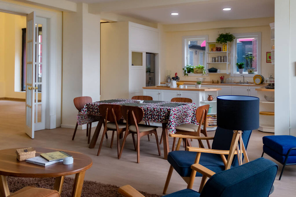 cucina con sala da pranzo fiorita, sedie in legno e accenti blu. Arredamento moderno - Foto, immagini
