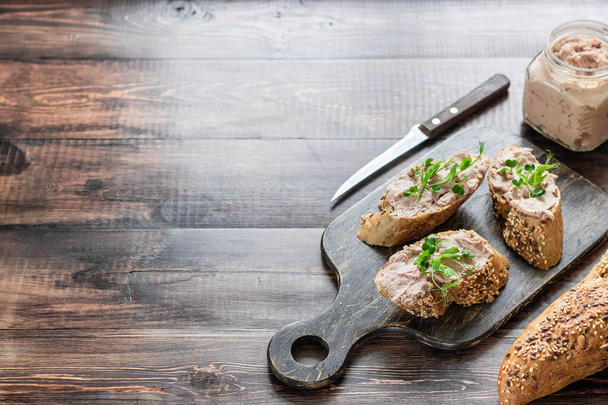 Turkey liver pate on a whole grain baguette with pea sprouts. A simple and comfortable snack - Photo, Image