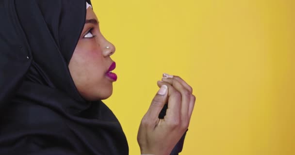 Μουσουλμάνα γυναίκα με παραδοσιακά ρούχα προσεύχεται σε φωτεινό φόντο  - Πλάνα, βίντεο
