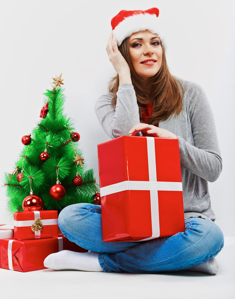 Santa woman seat near Christmas tree with christmas gift. - Фото, изображение