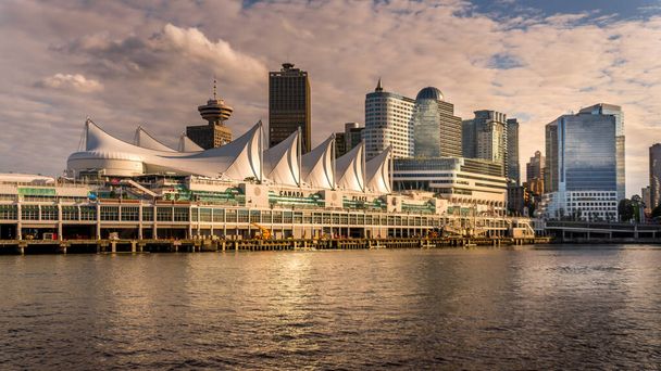 View of the Sun setting over Canada Place, the Cruise Ship Terminal at the shore of Burrard Inlet in Downtown Vancouver - Photo, Image