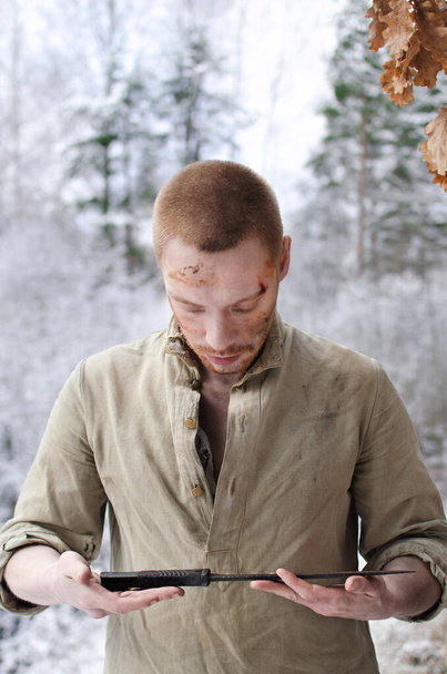 молодий чоловік у військовій формі Другої світової війни з бойовою ковдрою в руках у засніженому зимовому лісі
 - Фото, зображення