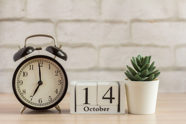 14 de octubre en un calendario de madera junto al despertador, la fecha del mes de otoño - Foto, Imagen