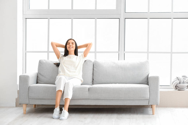 Mujer joven relajándose en el sofá en casa - Foto, imagen