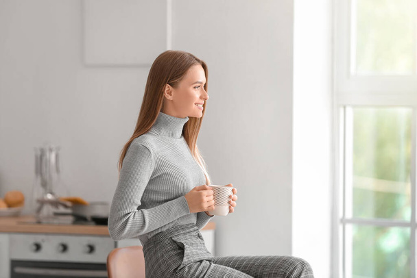 Krásná mladá žena pije čaj doma - Fotografie, Obrázek