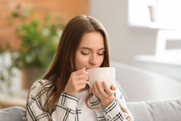 Beautiful young woman drinking tea at home - Foto, Imagem