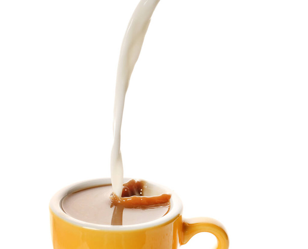 Pouring of milk in cup of hot coffee on white background - Photo, Image