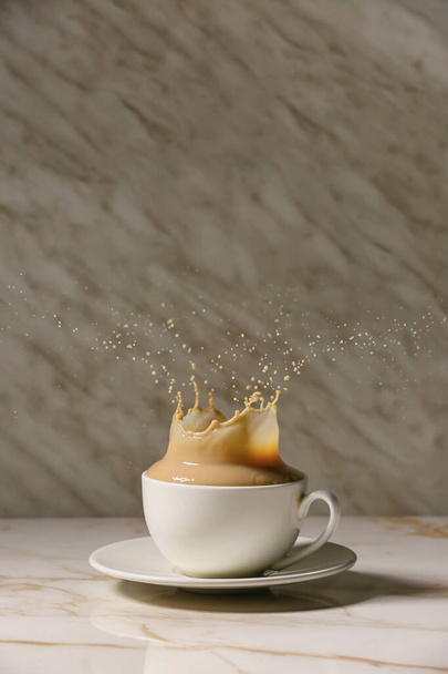 Cup of hot coffee with splash on table - Photo, Image