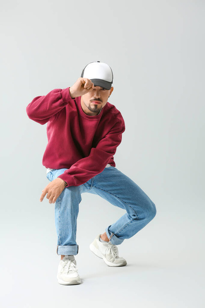 Mannelijke hip-hop danser op grijze achtergrond - Foto, afbeelding