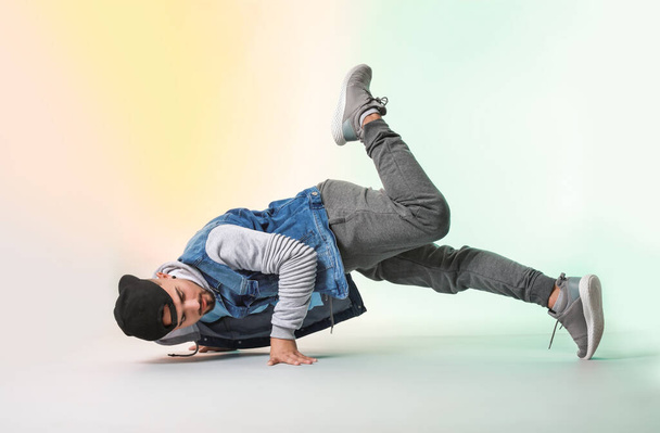Male hip-hop dancer on color background - Valokuva, kuva