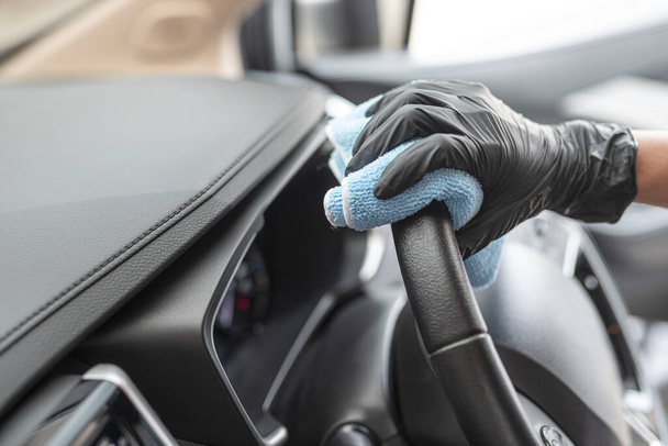 This image is a picture of wiping the car by a blue microfiber cloth with hand wearing gloves.Car wash concept. - Foto, Imagem