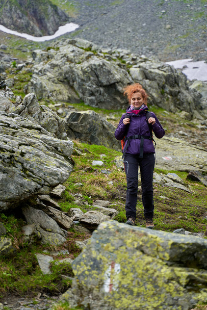 turista feminina com mochila caminhadas em uma trilha nas montanhas
 - Foto, Imagem