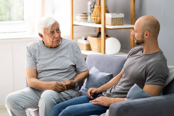 Grandpa Talking To His Grandson In Living Room - Zdjęcie, obraz