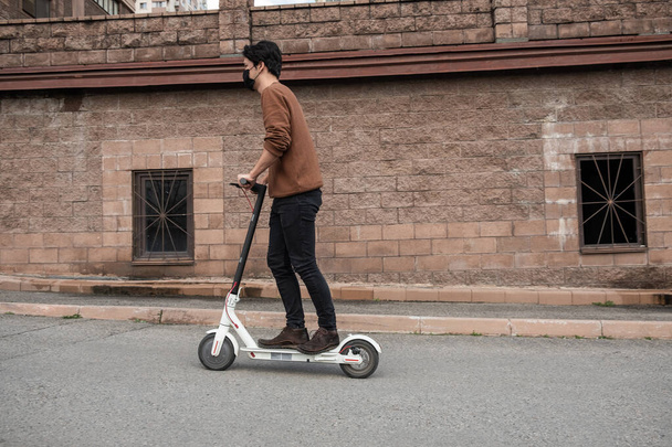 joven montando un scooter en la ciudad - Foto, Imagen