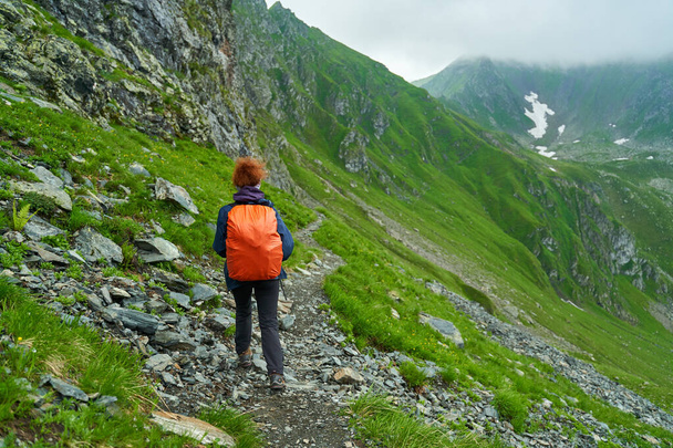 Žena turista s batohem pěší turistika na stezce v horách - Fotografie, Obrázek