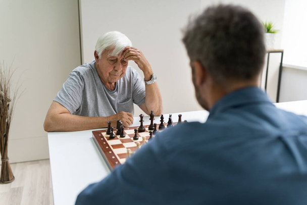 Elderly Senior Playing Chess Table Board Game - 写真・画像