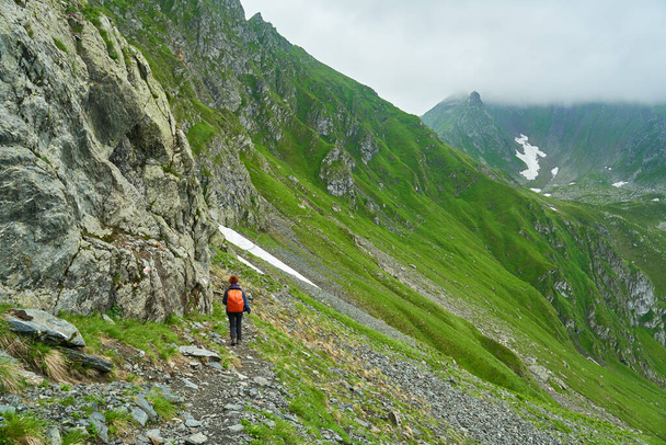 Touristin mit Rucksack wandert auf Wanderweg in den Bergen - Foto, Bild