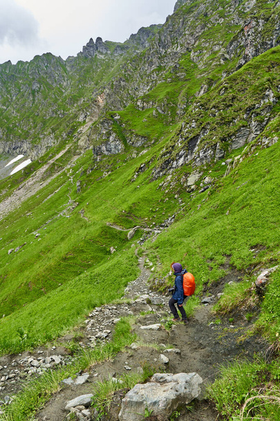 Žena turista s batohem pěší turistika na stezce v horách - Fotografie, Obrázek