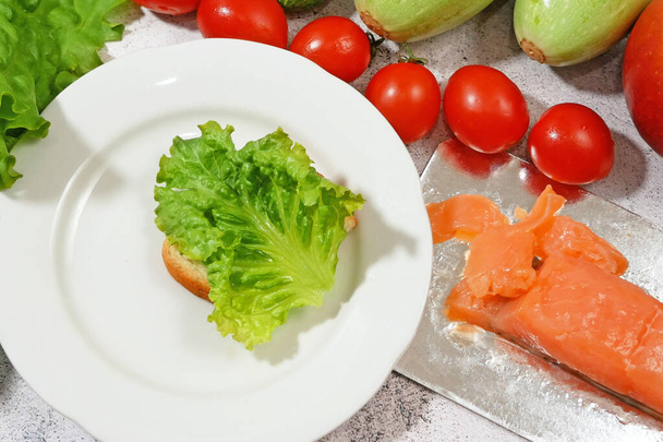 свежая рыба лосось с зеленым салатом и овощами, свежий салат с зеленью, лосось и гренки, сырая диета - Фото, изображение