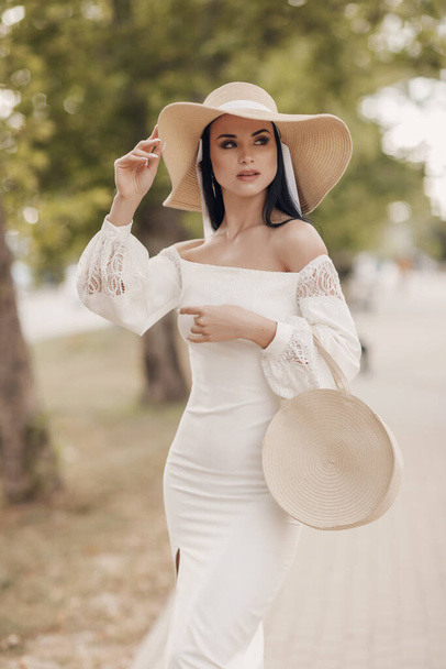 Fashion vrouw in jurk en hoed buiten - Foto, afbeelding