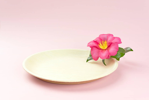 Natural disposable plate with pink tropical flower - Photo, Image