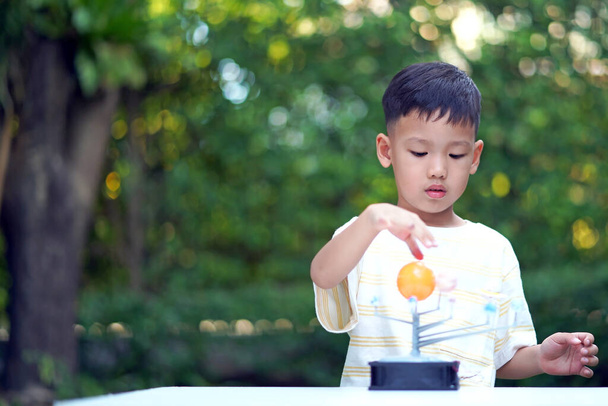 Aziatische jongen Living Solar System Speelgoed, Home Learning Equipment, tijdens nieuwe normale verandering na coronavirus of post covid-19 uitbraak pandemie situatie - Foto, afbeelding