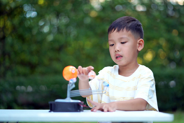 Азиатский мальчик Живые игрушки Солнечной системы, домашнее учебное оборудование, во время новых нормальных изменений после коронавируса или после ковида-19 вспышки пандемии ситуации - Фото, изображение