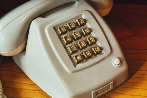 Stary zabytkowy telefon z drutem na drewnianej półce, retro design close-up nostalgia - Zdjęcie, obraz