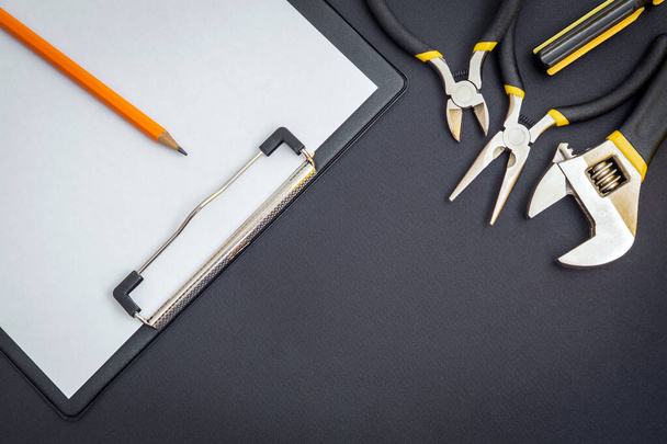 Tableta con una hoja de papel en blanco para la elaboración de un plan de trabajo y herramientas - Foto, Imagen