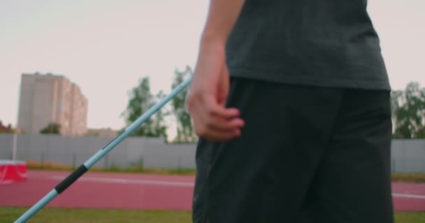 Detailní záběr: Hand a Male atlet na stadionu má oštěp pro házení a připravuje se hodit. Jde si pro kopí. Výcvik vrhače oštěpů - Záběry, video