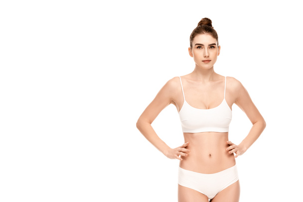 woman in panties and top standing with hands on hips and looking at camera isolated on white - Photo, Image