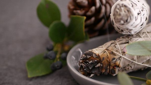 Dried white sage smudge stick, relaxation and aromatherapy. Smudging during psychic occult ceremony, herbal healing, yoga or aura cleaning. Essential incense for esoteric rituals and fortune telling. - Photo, Image