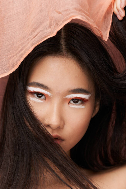 Azjatka z makijażem, różowy materiał - Zdjęcie, obraz