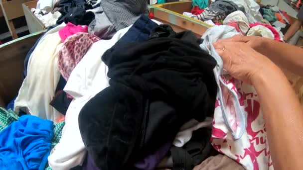 Frau blättert in Kleidungsstück im Thrift Store - Filmmaterial, Video