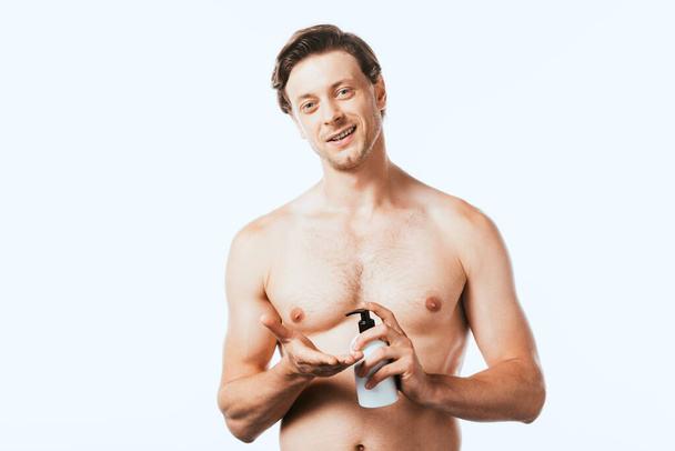 Shirtless man holding bottle of lotion and looking at camera isolated on white - Foto, Imagem
