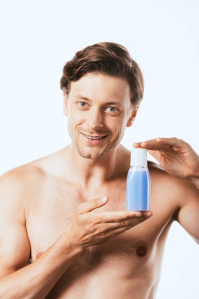 Shirtless man showing bottle of toner isolated on white - Fotoğraf, Görsel