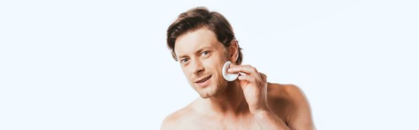 Panoramic shot of shirtless man holding cotton pad near face isolated on white - Фото, зображення