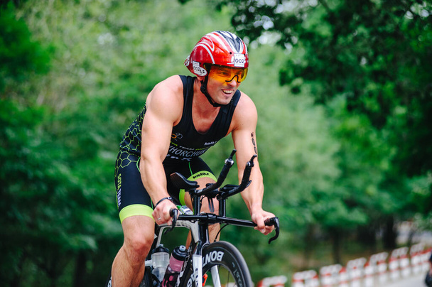 KHARKIV, UKRAINE - August 2, 2020: Triathon biking cyclist triathlete riding racing bike during ironman competition. Road cycling athlete in tri suit and helmet. Public events are allowed. Europe sport during CV pandemic. - Foto, Imagen