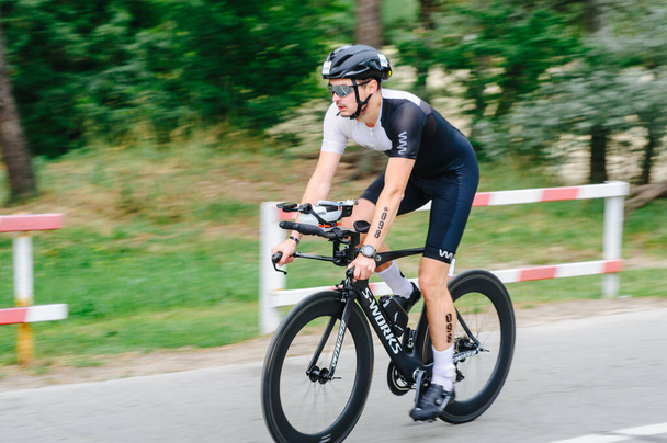 KHARKIV, UKRAINE - August 2, 2020: Triathon biking cyclist triathlete riding racing bike during ironman competition. Road cycling athlete in tri suit and helmet. Public events are allowed. Europe sport during CV pandemic. - Photo, Image