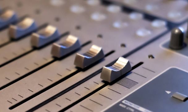 マルチトラックオーディオサウンドミキサーテーブルを閉じる-サウンド音響音楽エンジニアリングの概念の背景-選択的フォーカス - 写真・画像
