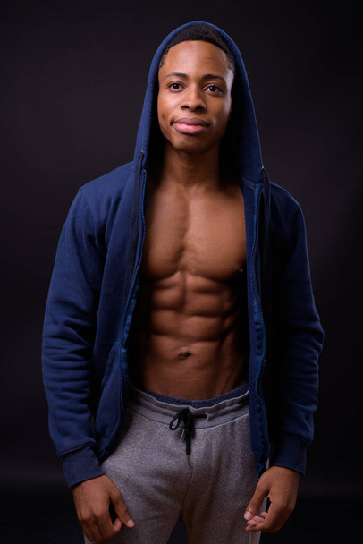 Stúdió lövés fiatal jóképű afrikai férfi fekete háttér - Fotó, kép