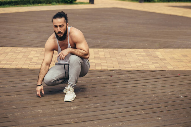 Athletic man with muscular body resting after workout outdoors - Photo, image