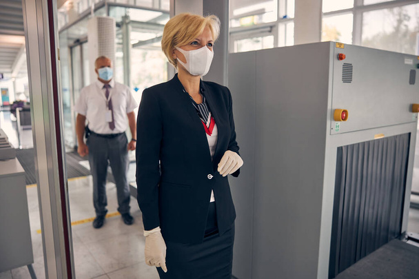 Charming woman walking through security control gate at airport - Foto, afbeelding