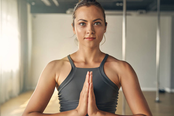 Attractive young woman doing yoga exercise in studio - Fotoğraf, Görsel