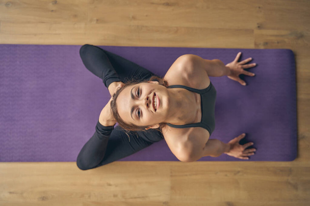 Joyful young woman doing backbend yoga pose - Foto, afbeelding