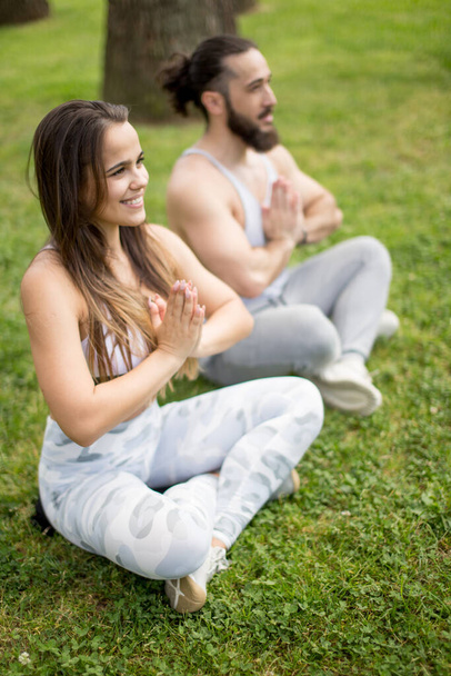 Young couple doing yoga outdoors - Foto, Imagen