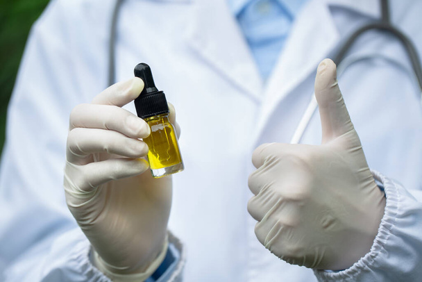 Doktor drží láhev konopného oleje v pipetě, marihuana alternativní bylinné medicíny koncept. CBD konopný olej vědců.  - Fotografie, Obrázek